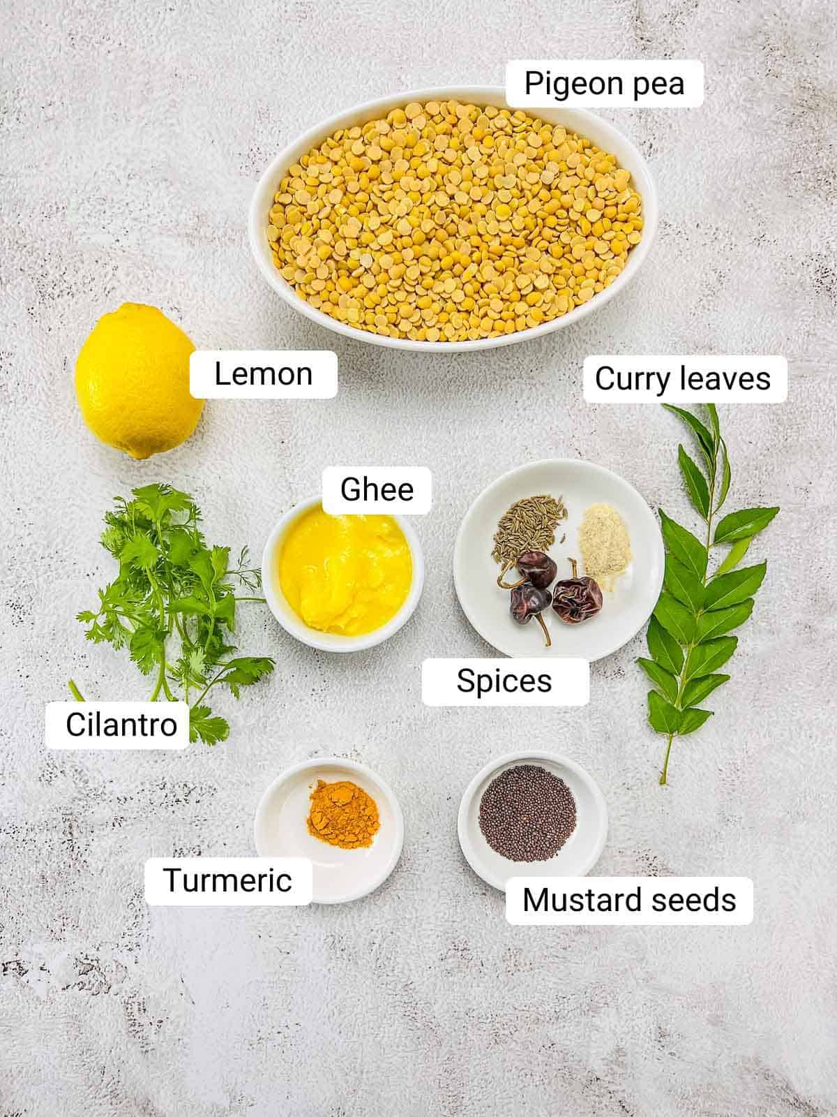 Ingredients to make home-style dal placed on a white surface.