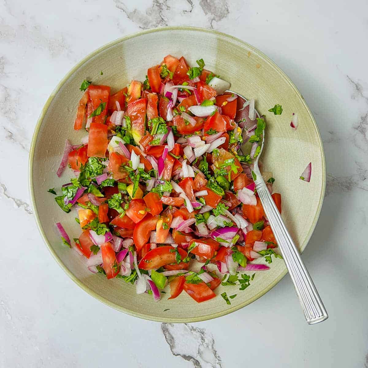 Pico de gallo in a brown bowl.