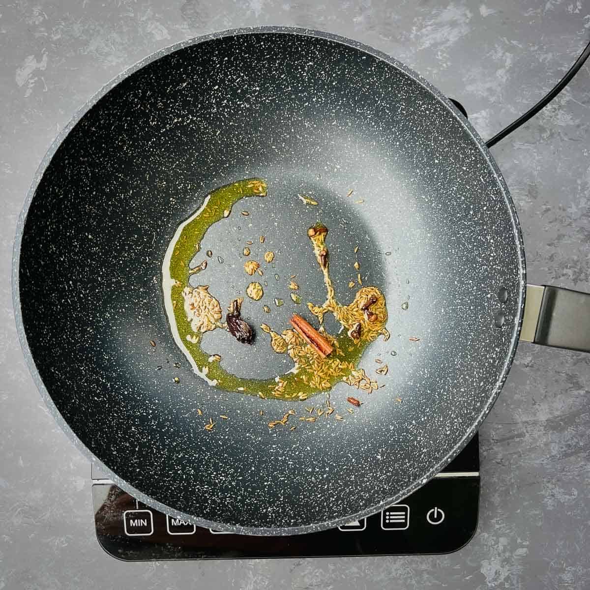 Spices tempered in a frying pan.