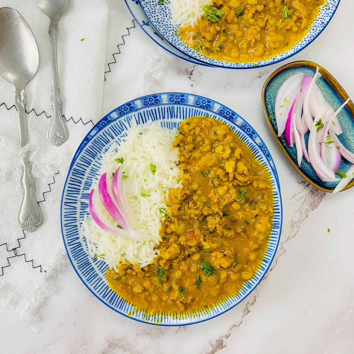 Keema green moong curry and rice on a blue plate.