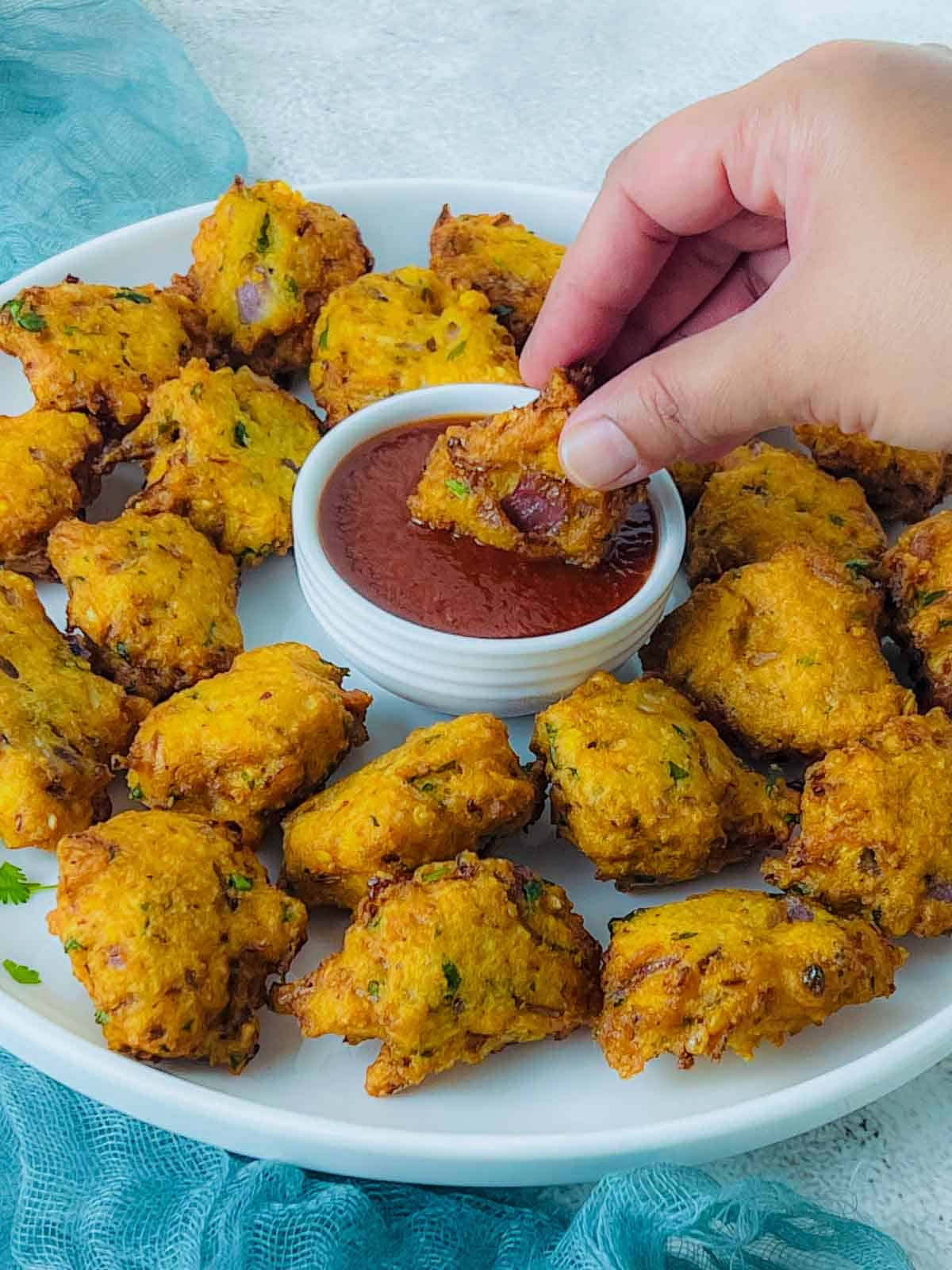 A red lentil fritter dipped in ketchup.