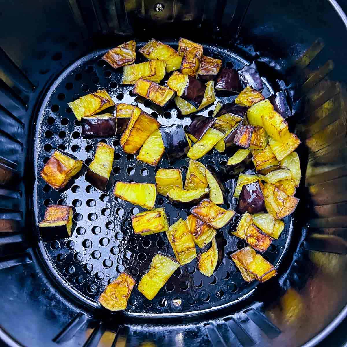 Roasted eggplants in air fryer basket.