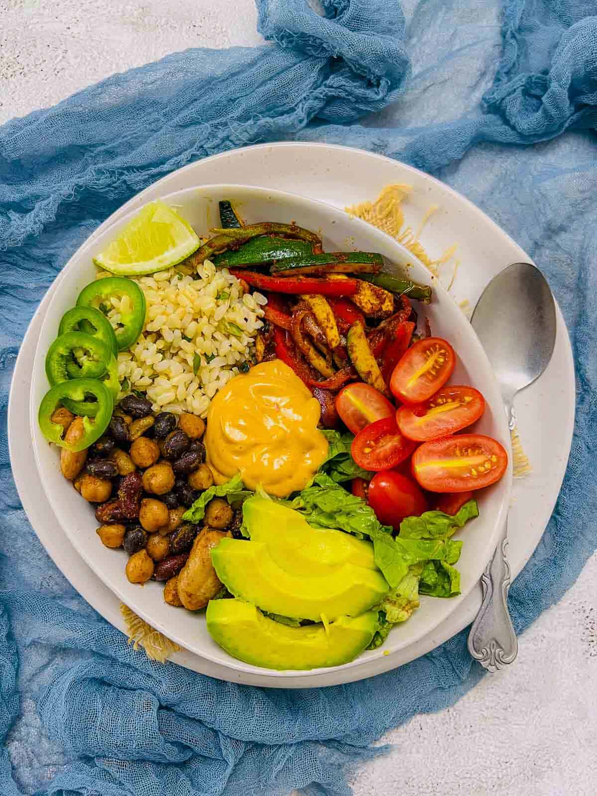 Taco Buddha bowl with mixed beans placed on a white plate.