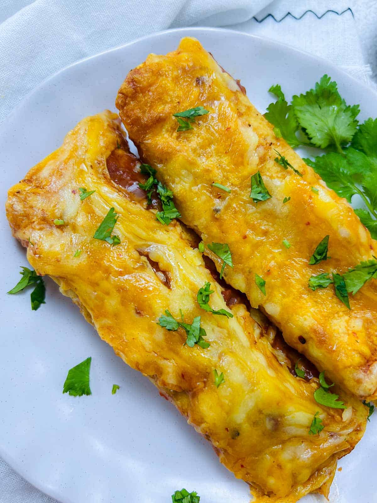 Chicken lentil enchiladas on a white plate.