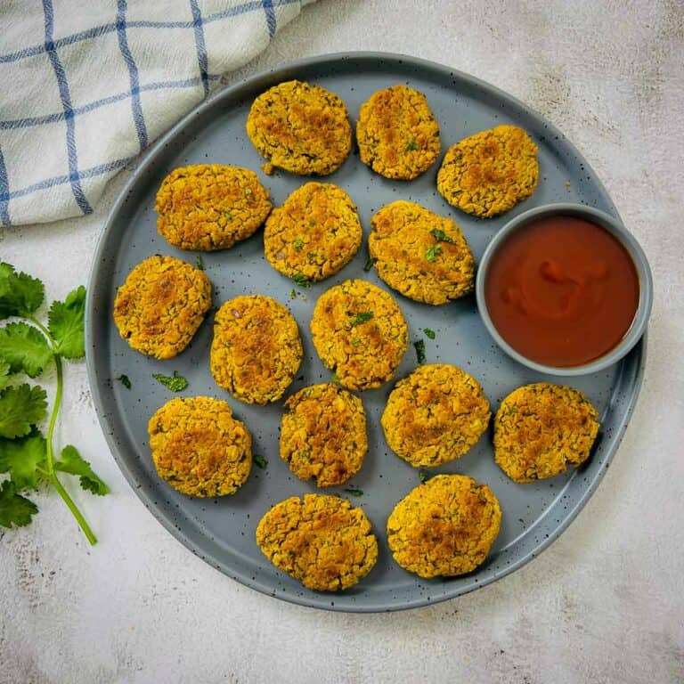 Chickpea nuggets on a grey plate served with ketchup.