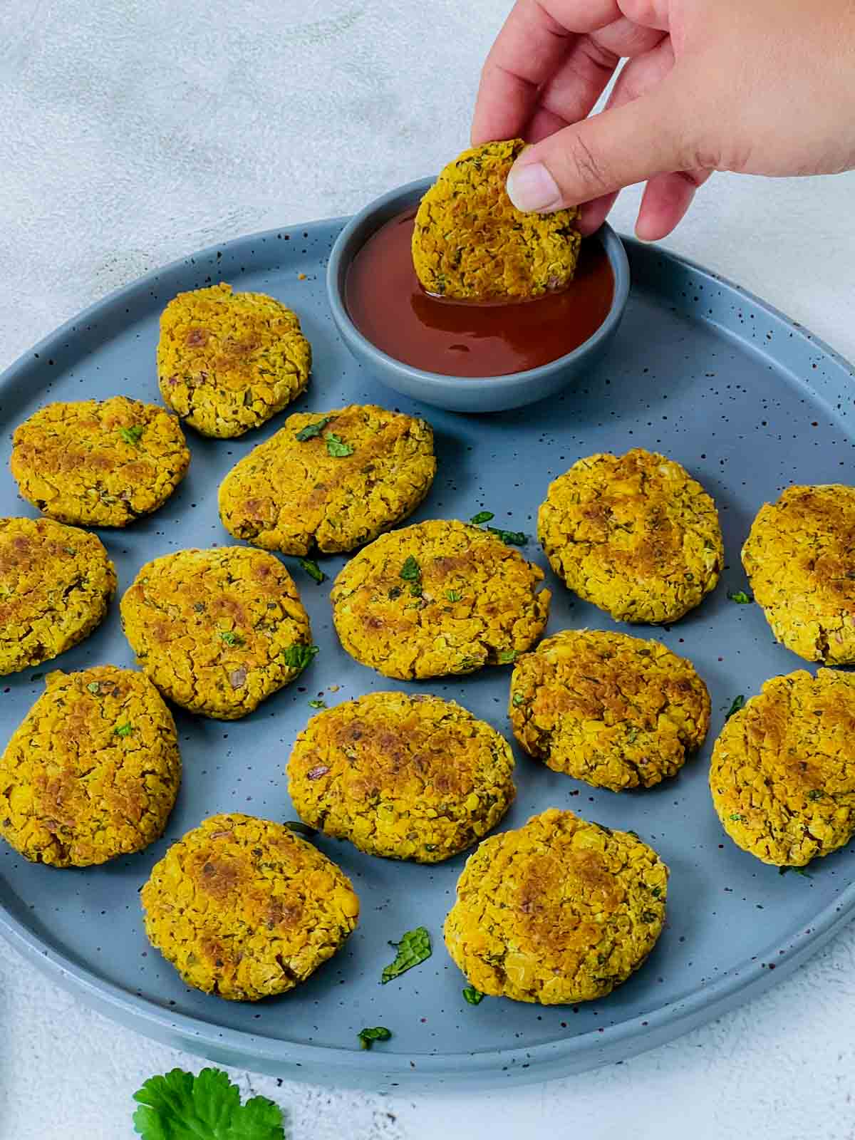 Chickpea nugget dipped in tomato ketchup.
