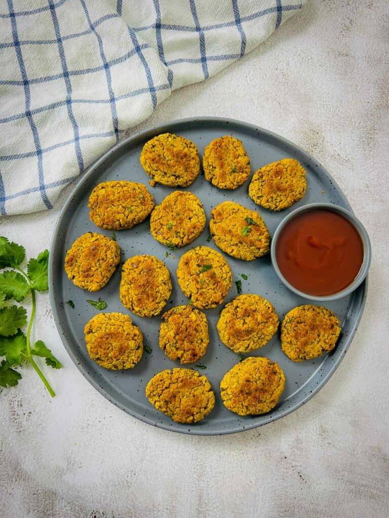 Chickpea nuggets on a grey plate with cilantro in the background.