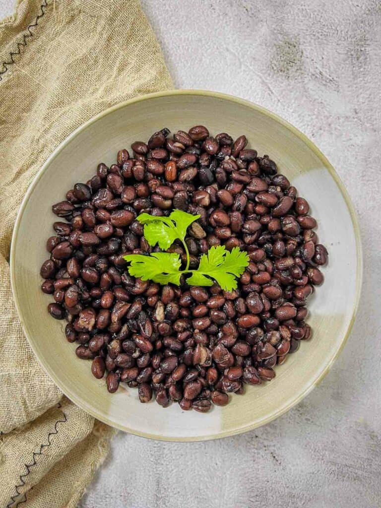 Cooked black beans in a brown bowl.