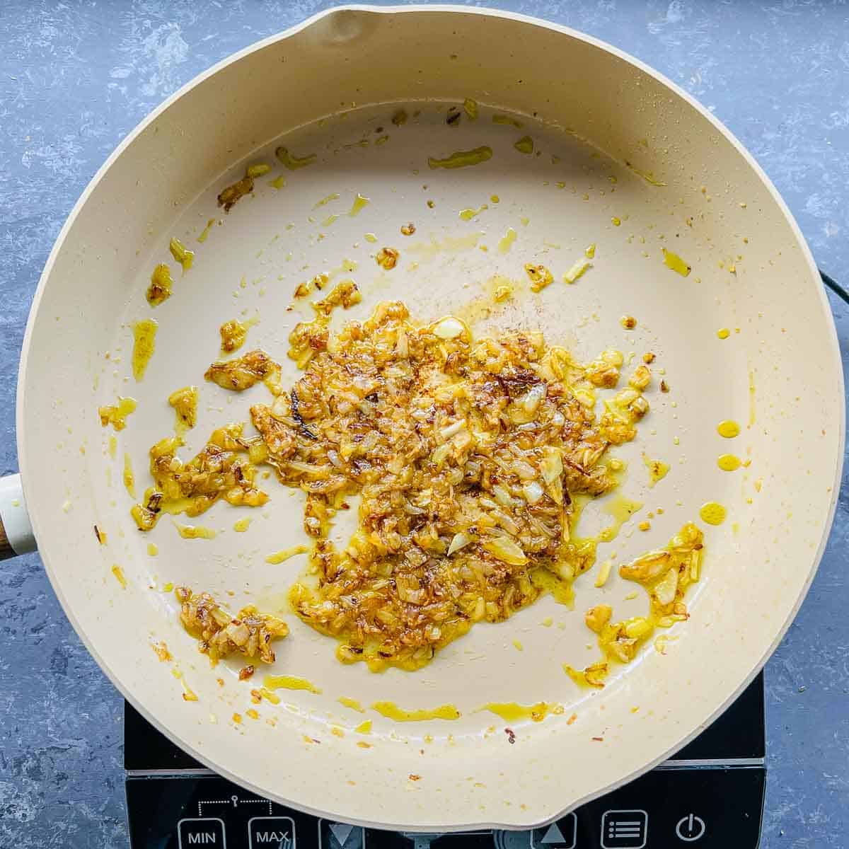 Onion, ginger, garlic sauted in a frying pan.