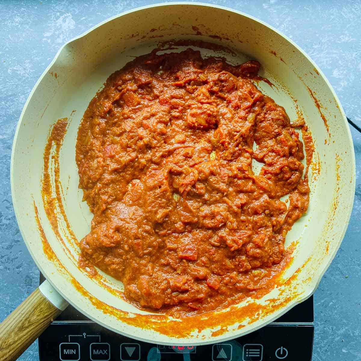 Tomatoes and spices cooked in the frying pan.
