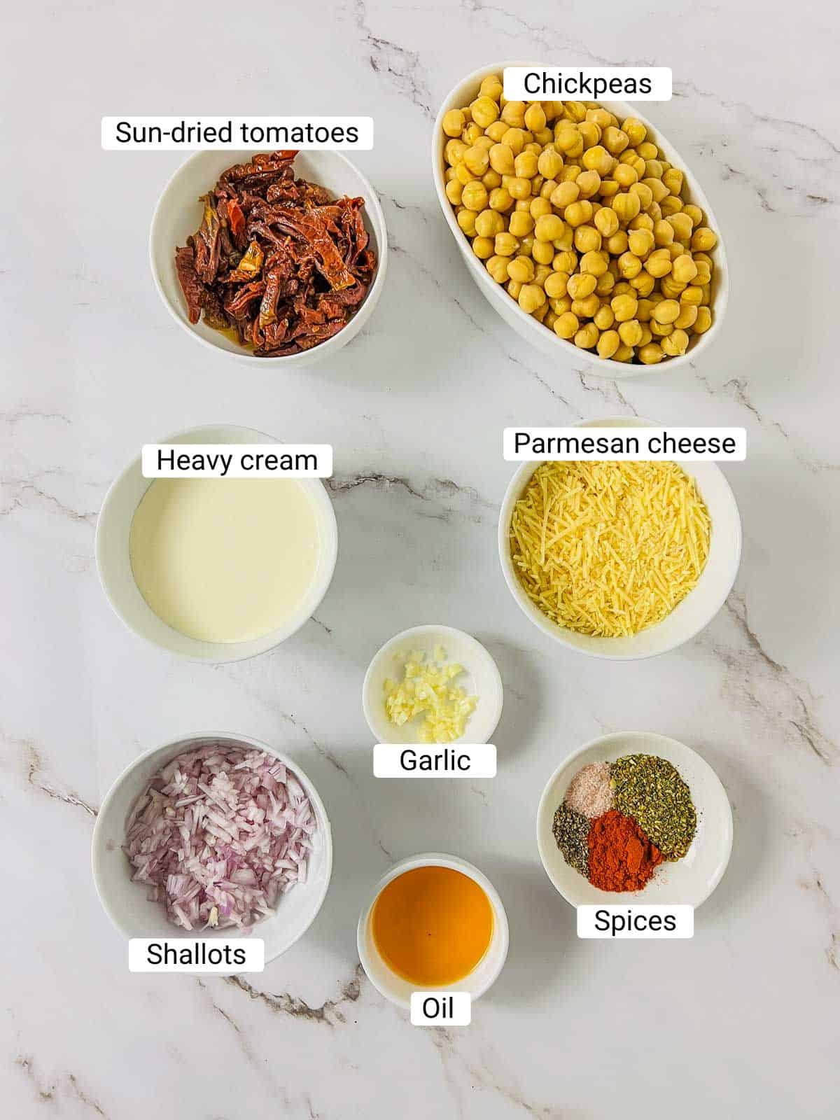 Ingredients to make marry me chickpeas on a white surface.