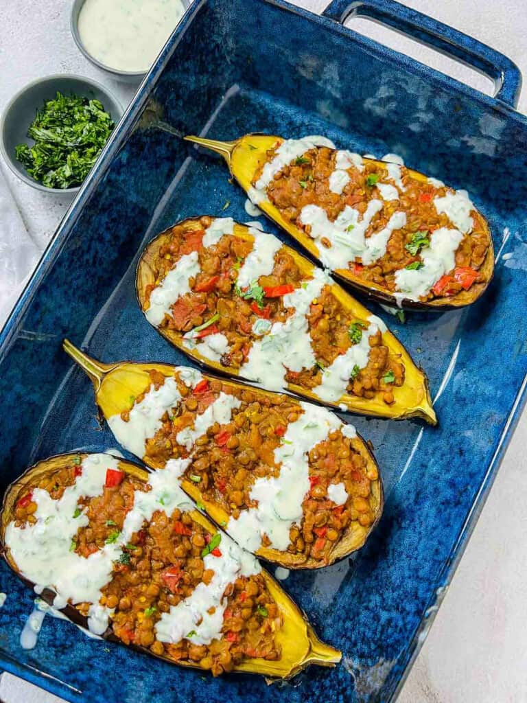 Lentil stuffed eggplant in a blue baking dish.