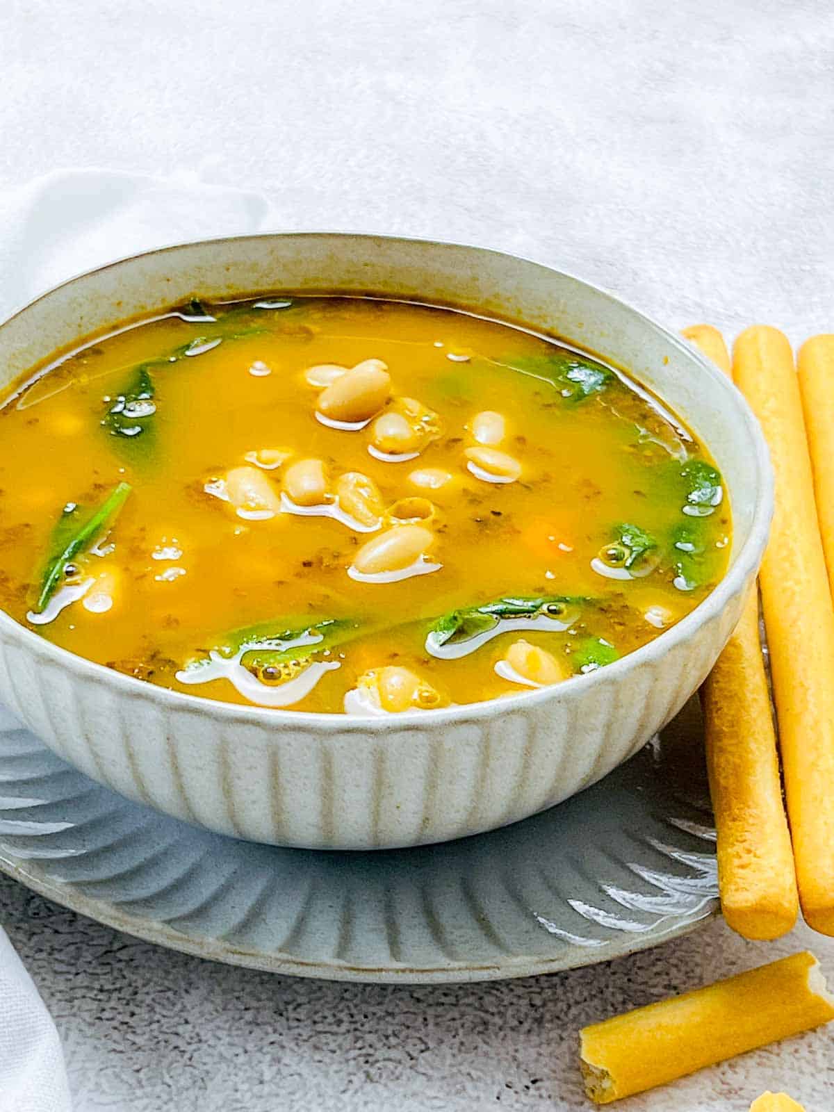 White bean soup served with bread sticks.