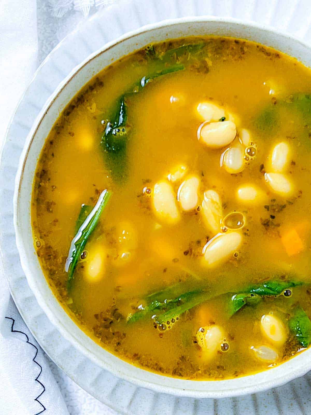 White bean soup with spinach close up.