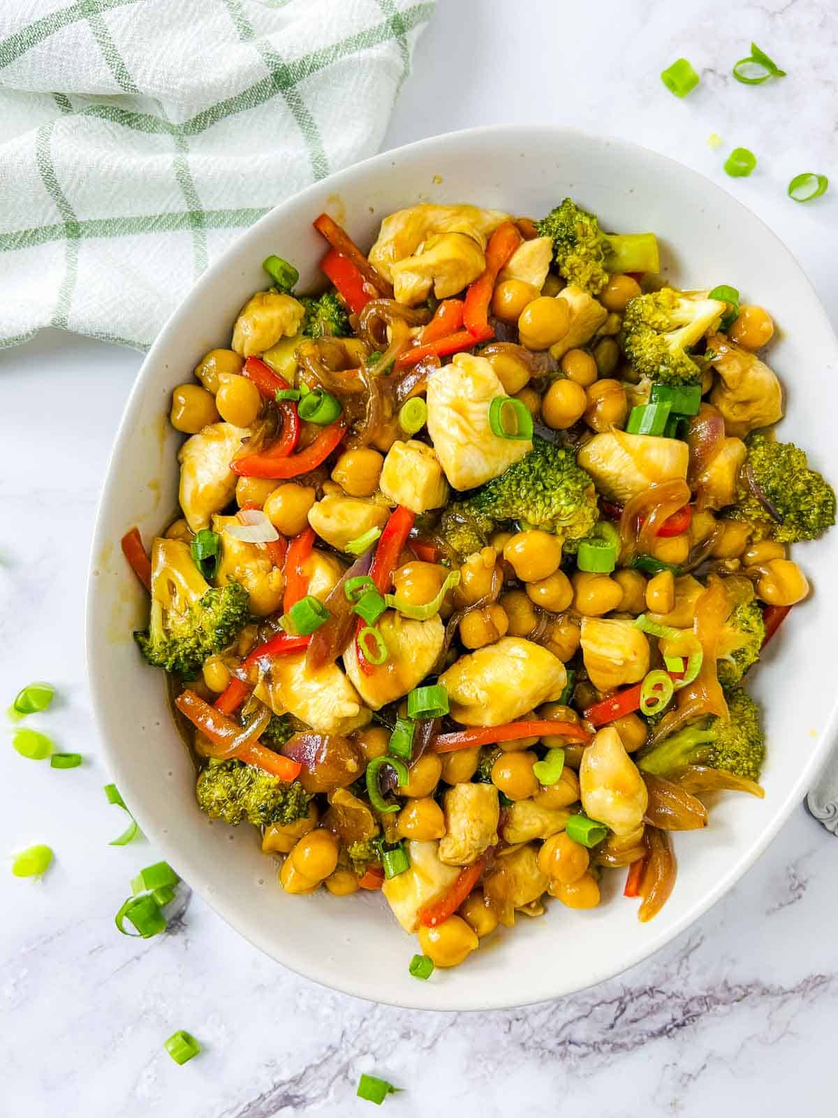 Chicken chickpea stir fry garnished with scallions.