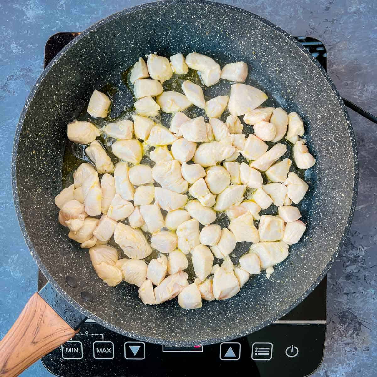 Chicken sauted in frying pan.