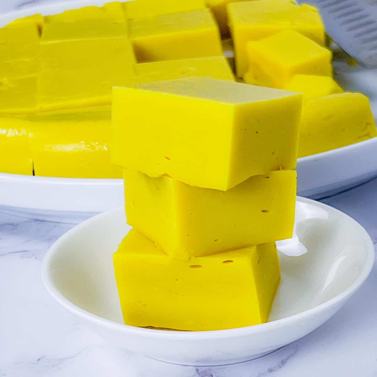 A stack of homemade chickpea tofu on a small white plate.