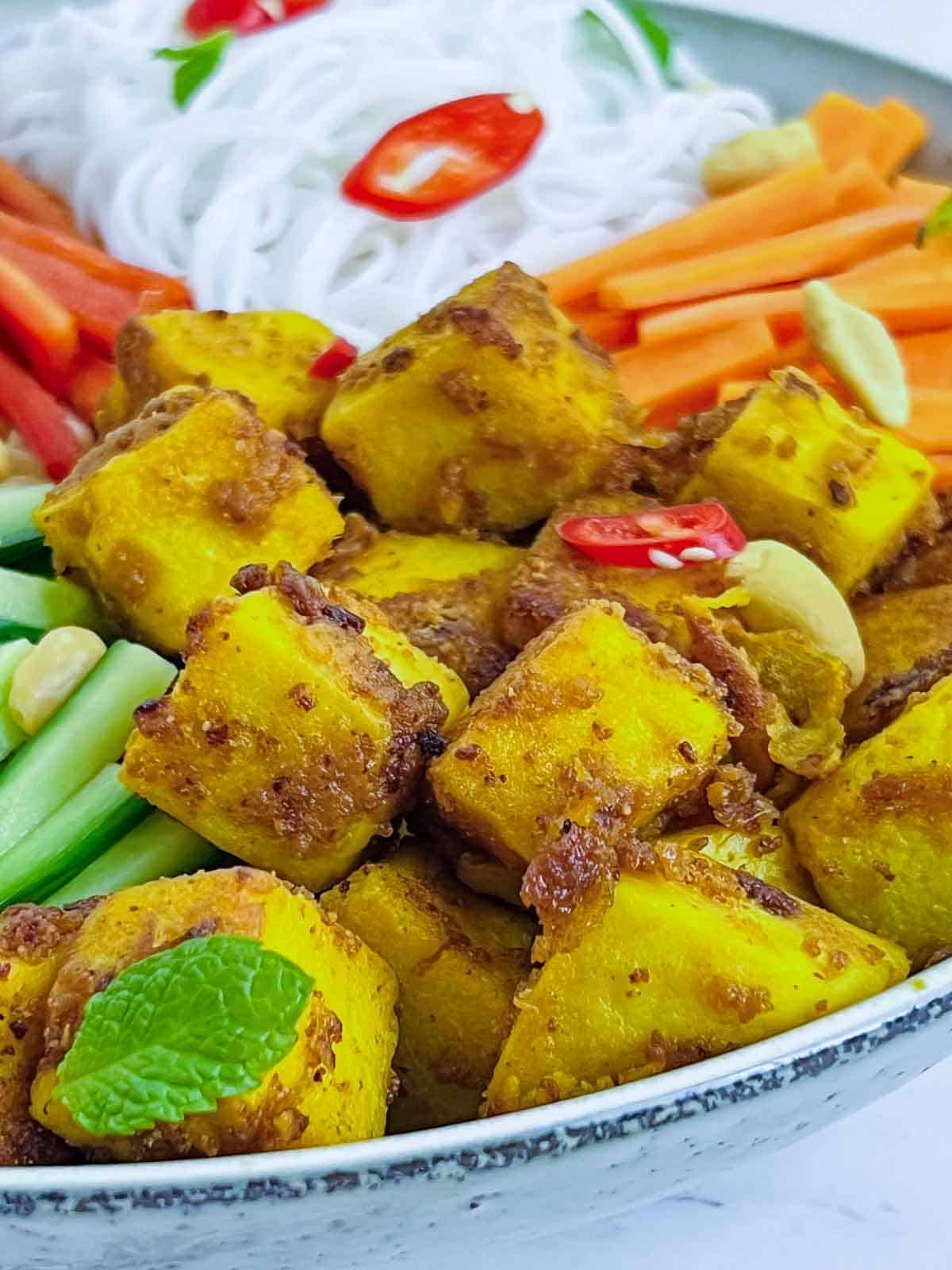 Roasted chickpea tofu placed in the Buddha bowl.