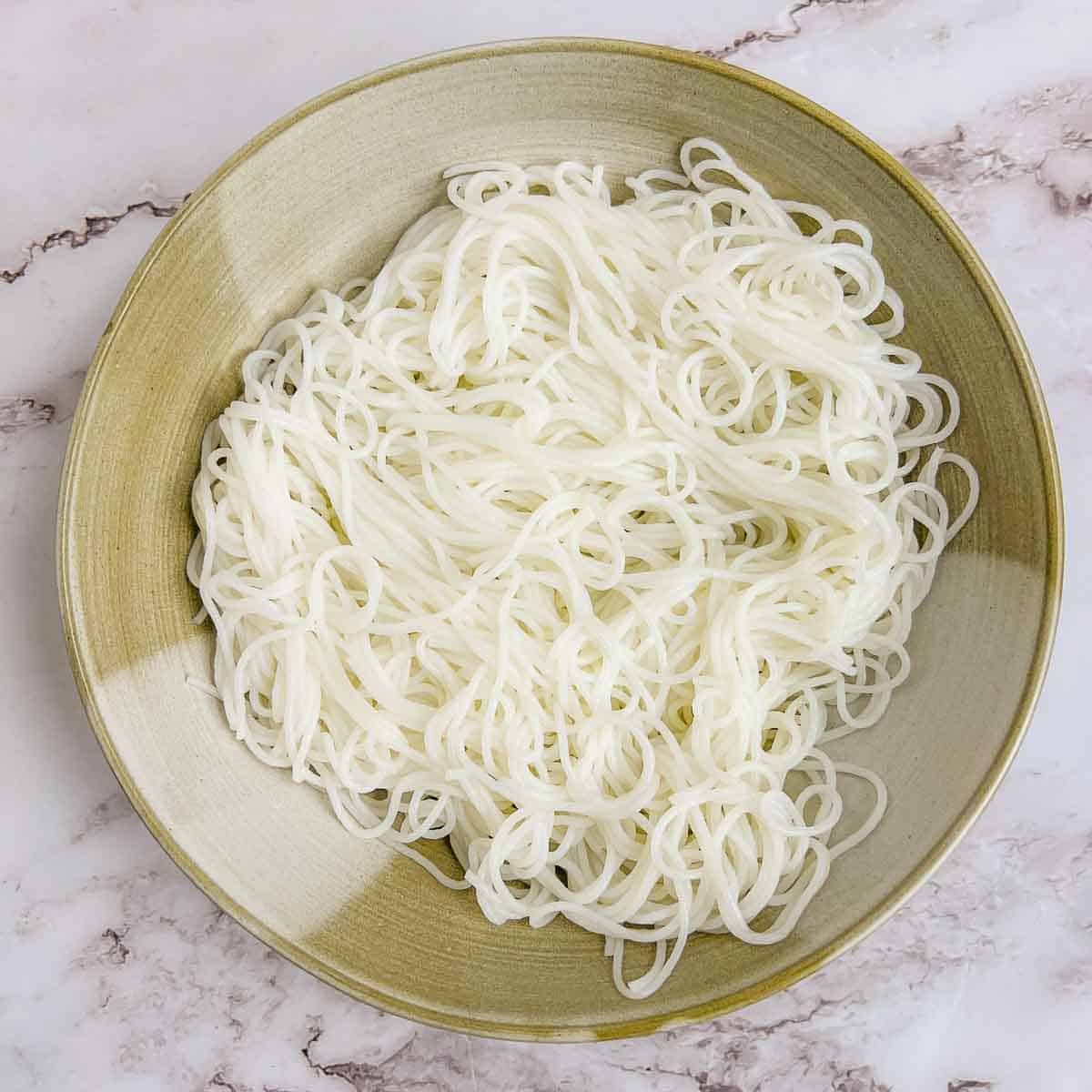 Boiled noodles in a brown bowl.
