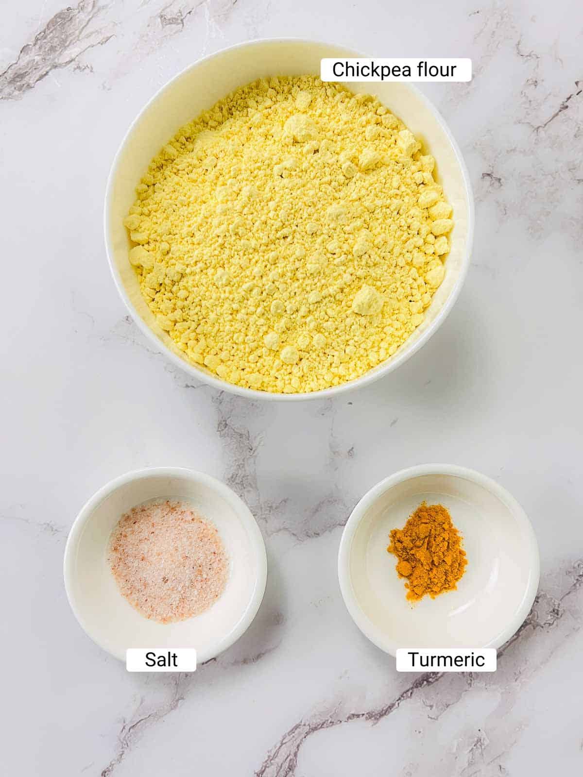 Ingredients to make chickpea tofu on a white surface.