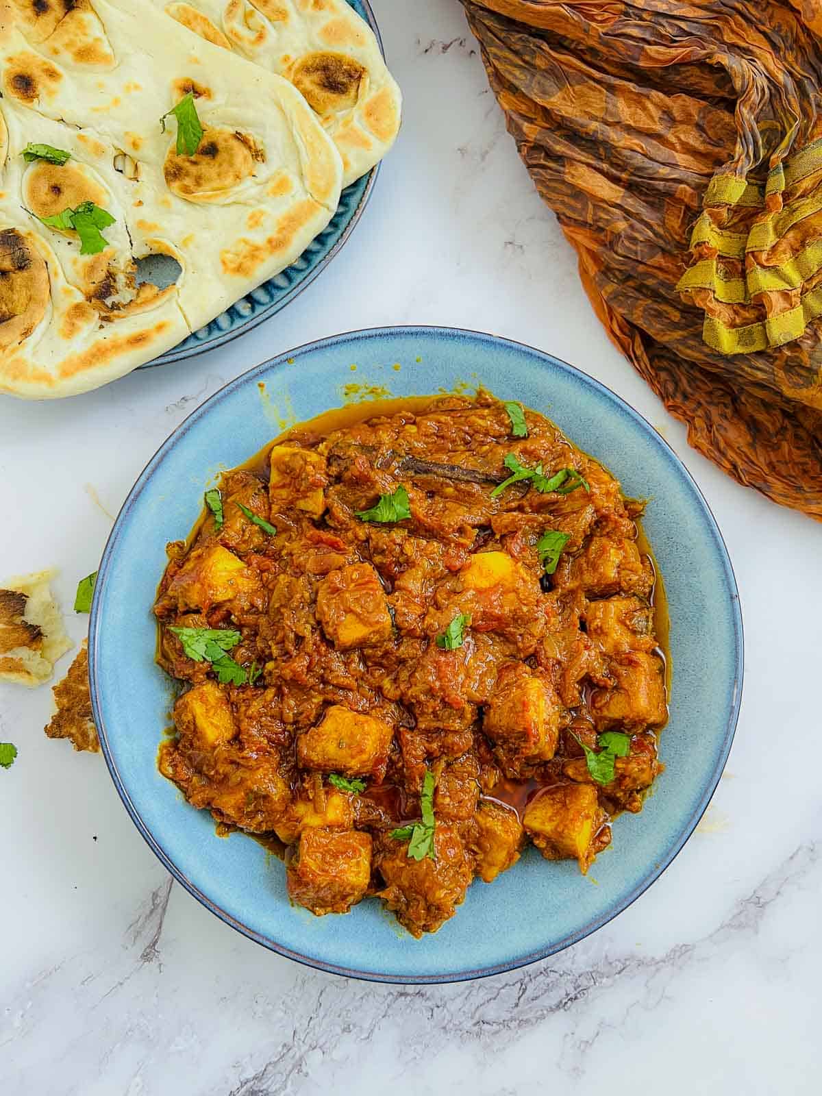 Chickpea tofu in a blue bowl served with naan.
