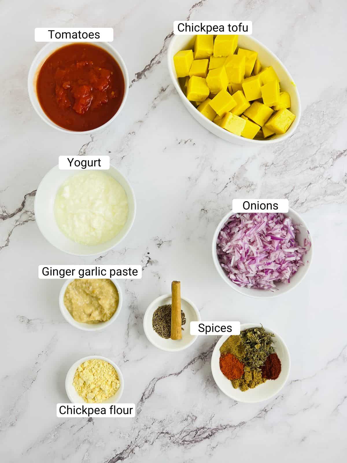 Ingredients to make chickpea tofu tikka masala on a marble surface.