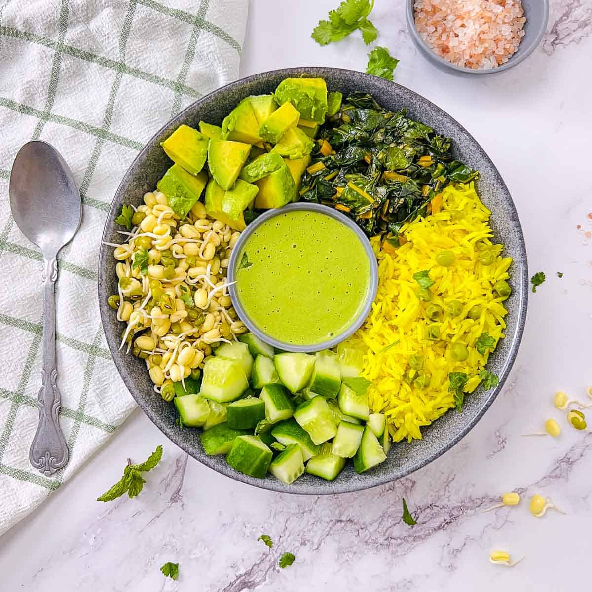 Green goddess power bowl with a spoon in the background.
