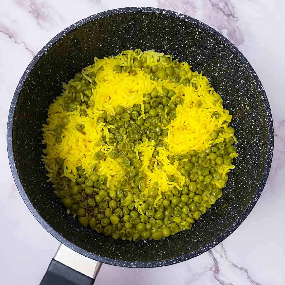 Green peas rice cooked in a saucepan.