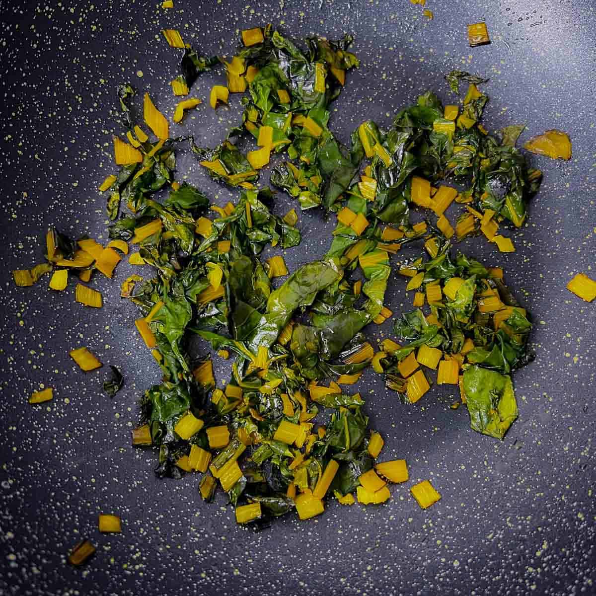 Swiss chards sauté in a frying pan.