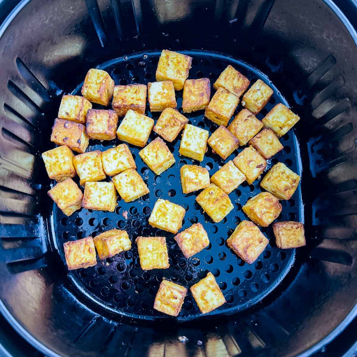 Roasted paneer in air fryer basket.