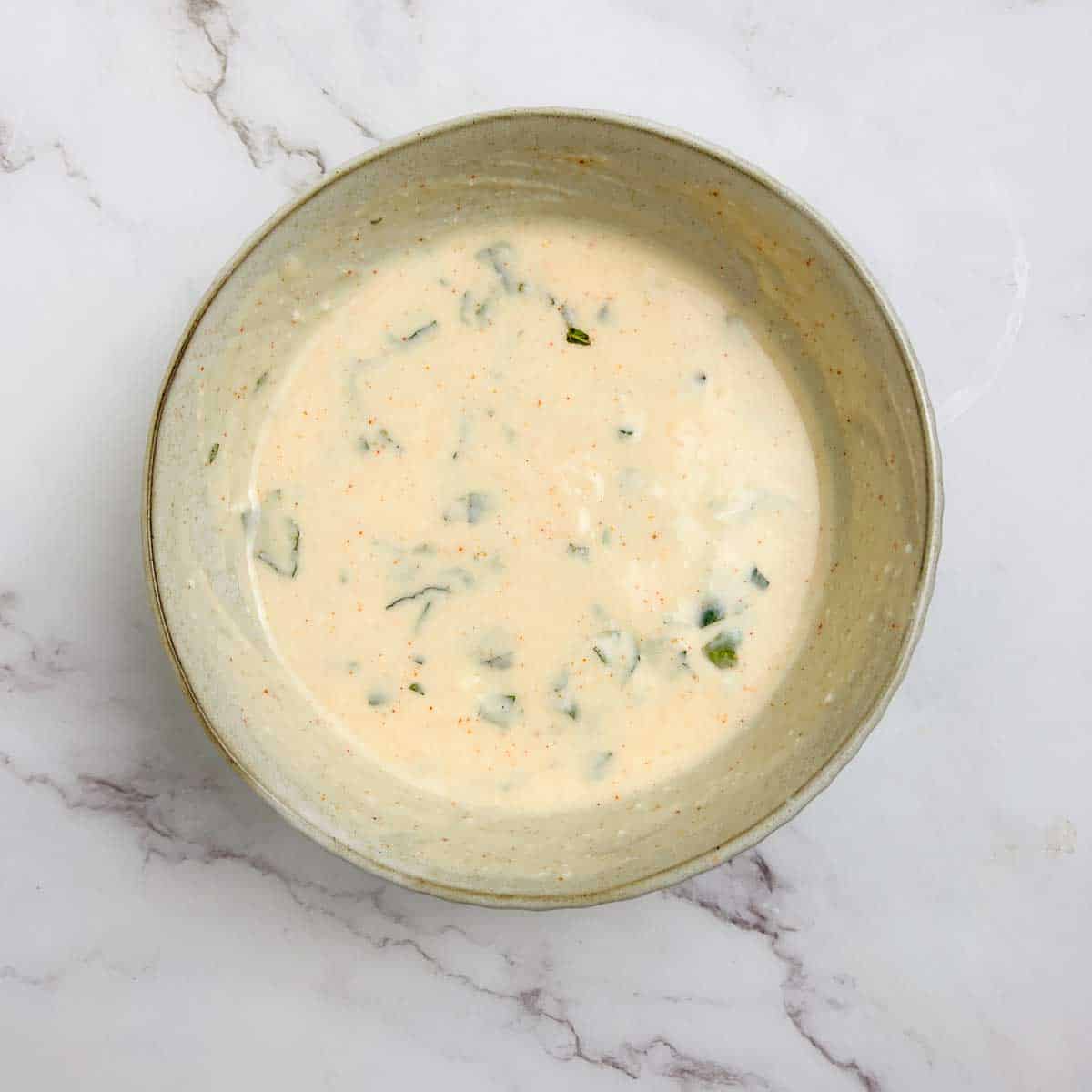Salad dressing in a small bowl.