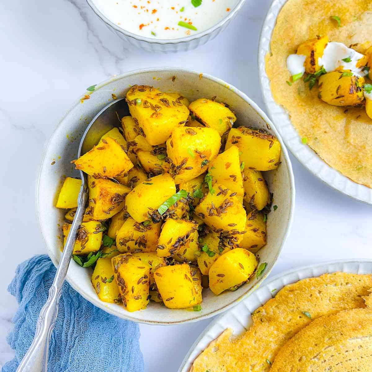 Cumin-flavored potatoes in a white bowl.