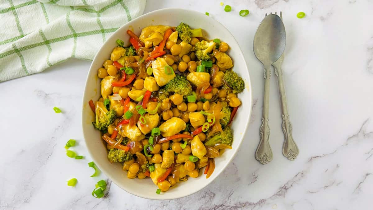Chicken chickpea stir fry in a white bowl.
