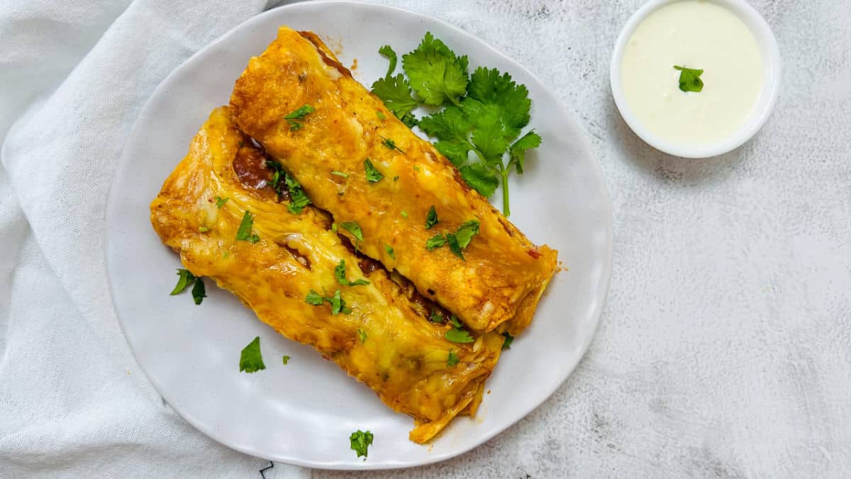 Chicken lentil enchiladas on a white plate.
