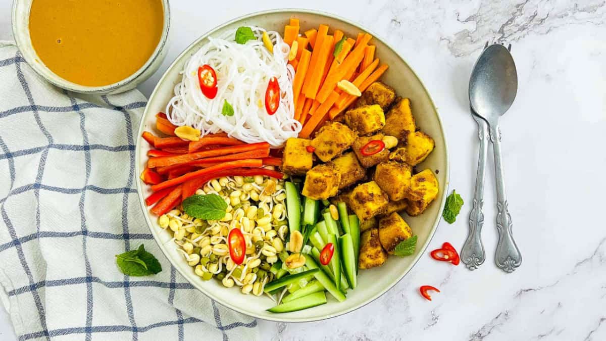 Chickpea tofu Buddha bowl on a marble surface.