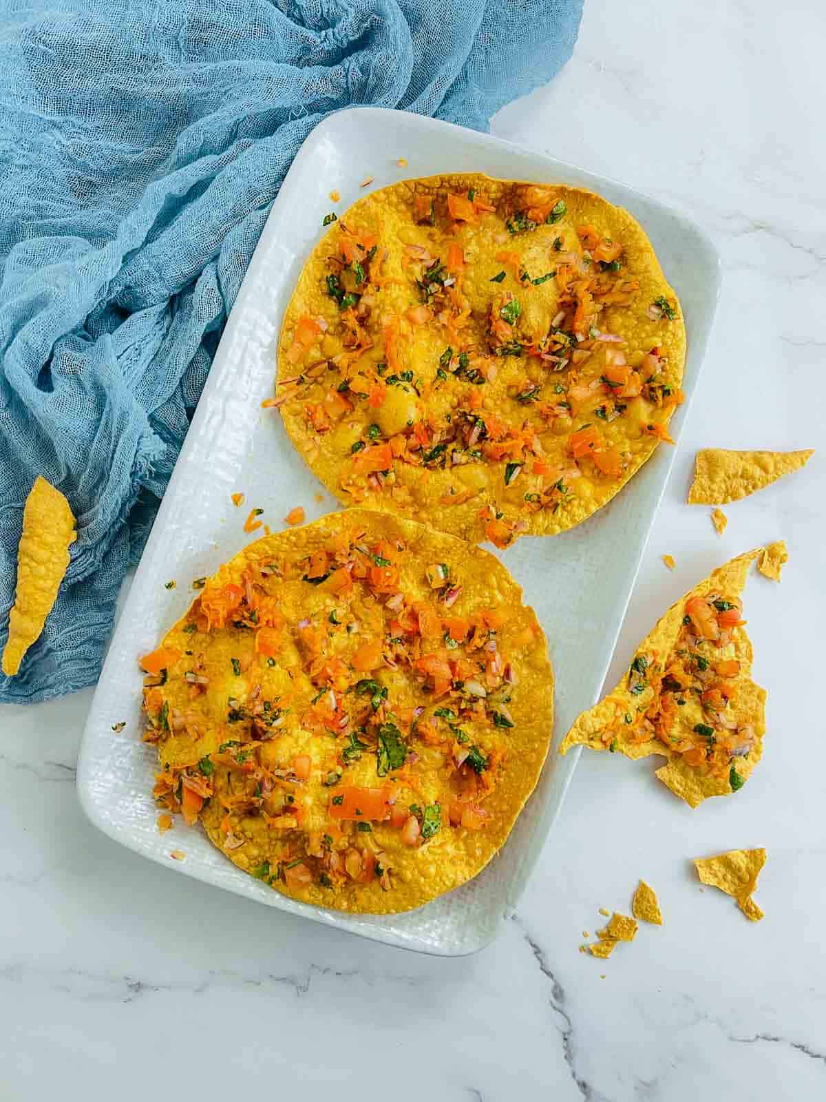 Two masala papads on a white plate.
