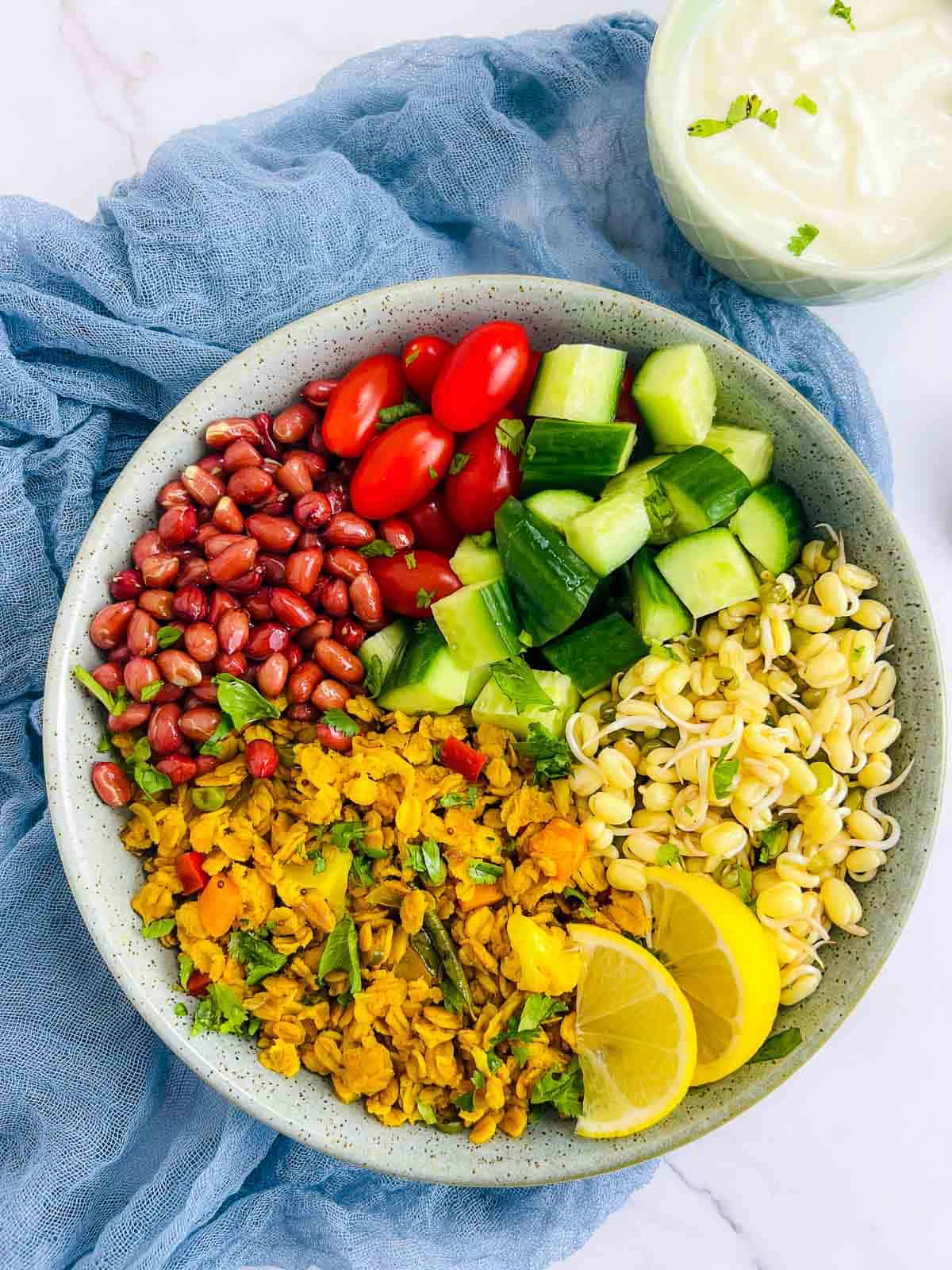 Oats upma breakfast bowl served with yogurt in the background.