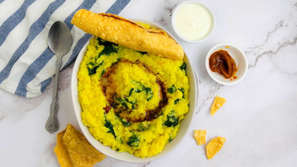 Palak khichdi bowl on a marble surface.