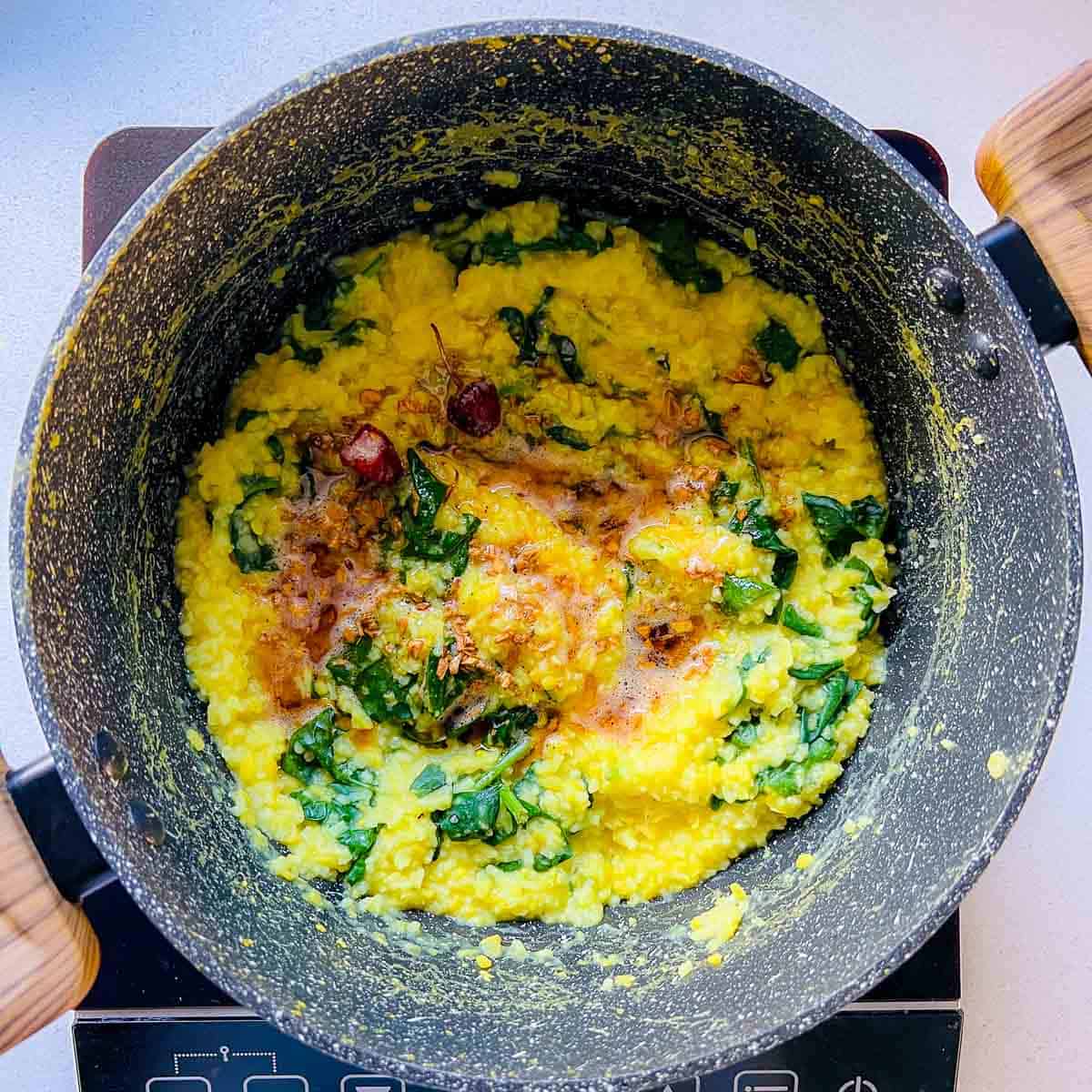 Tadka topped on the khichdi in the pan.