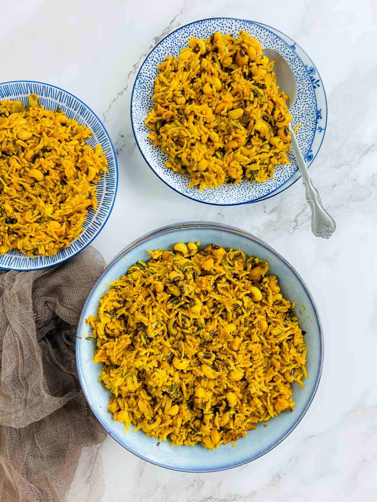 Indian-style black eyed peas and rice in blue bowl and plates.