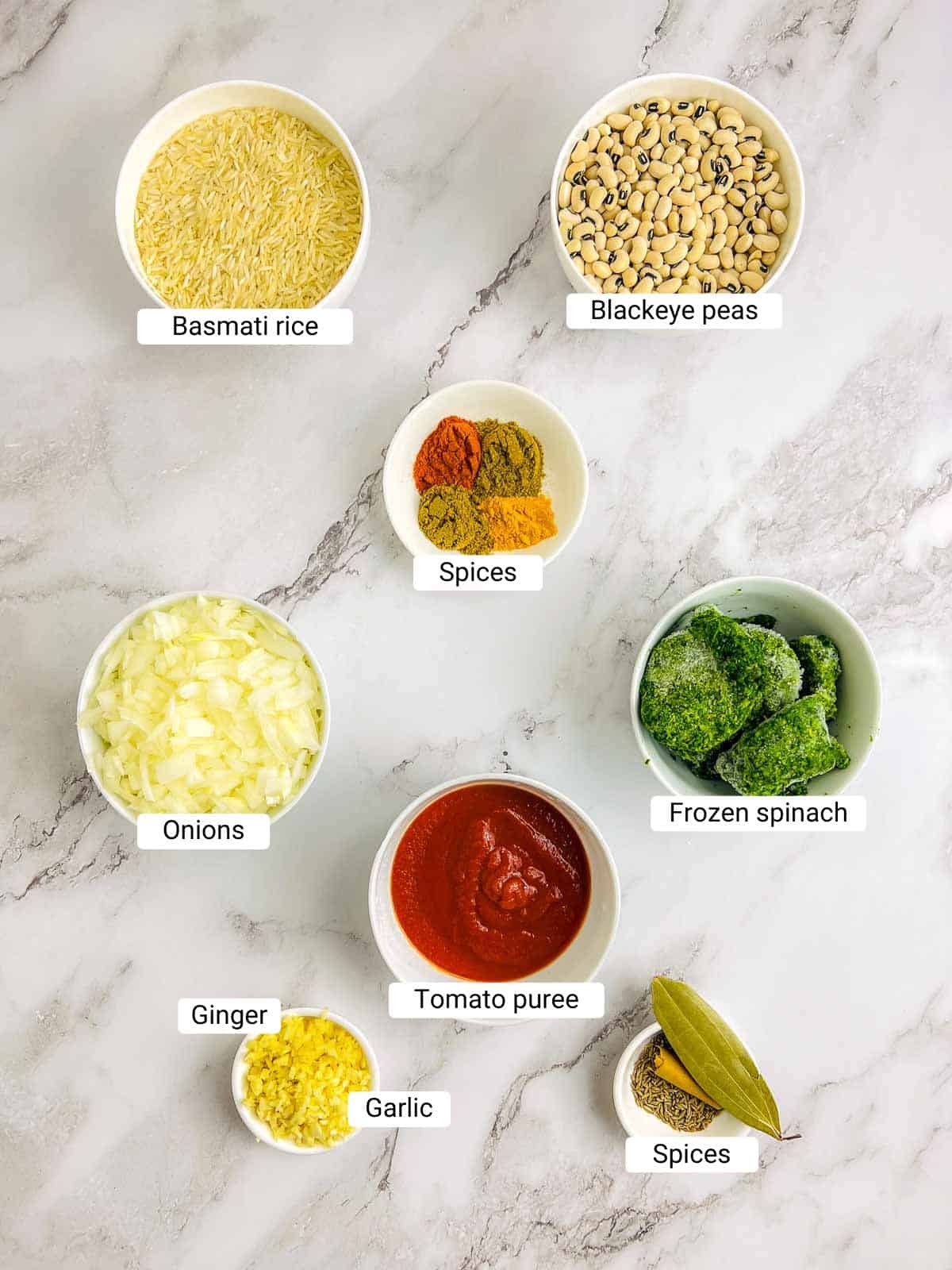 Ingredients to make spiced hoppin john on a marble surface.