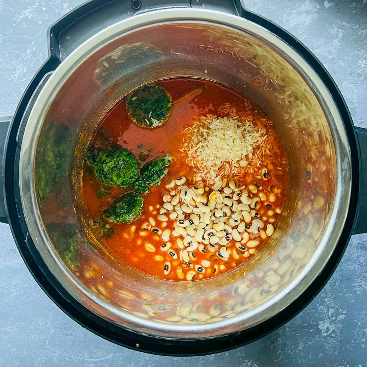 Black eyed peas, rice, spinach, and water added to the Instant Pot.