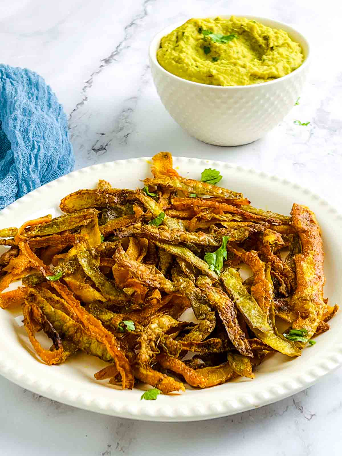 Vegetable peel chips and curried bean dip garnished with cilantro.