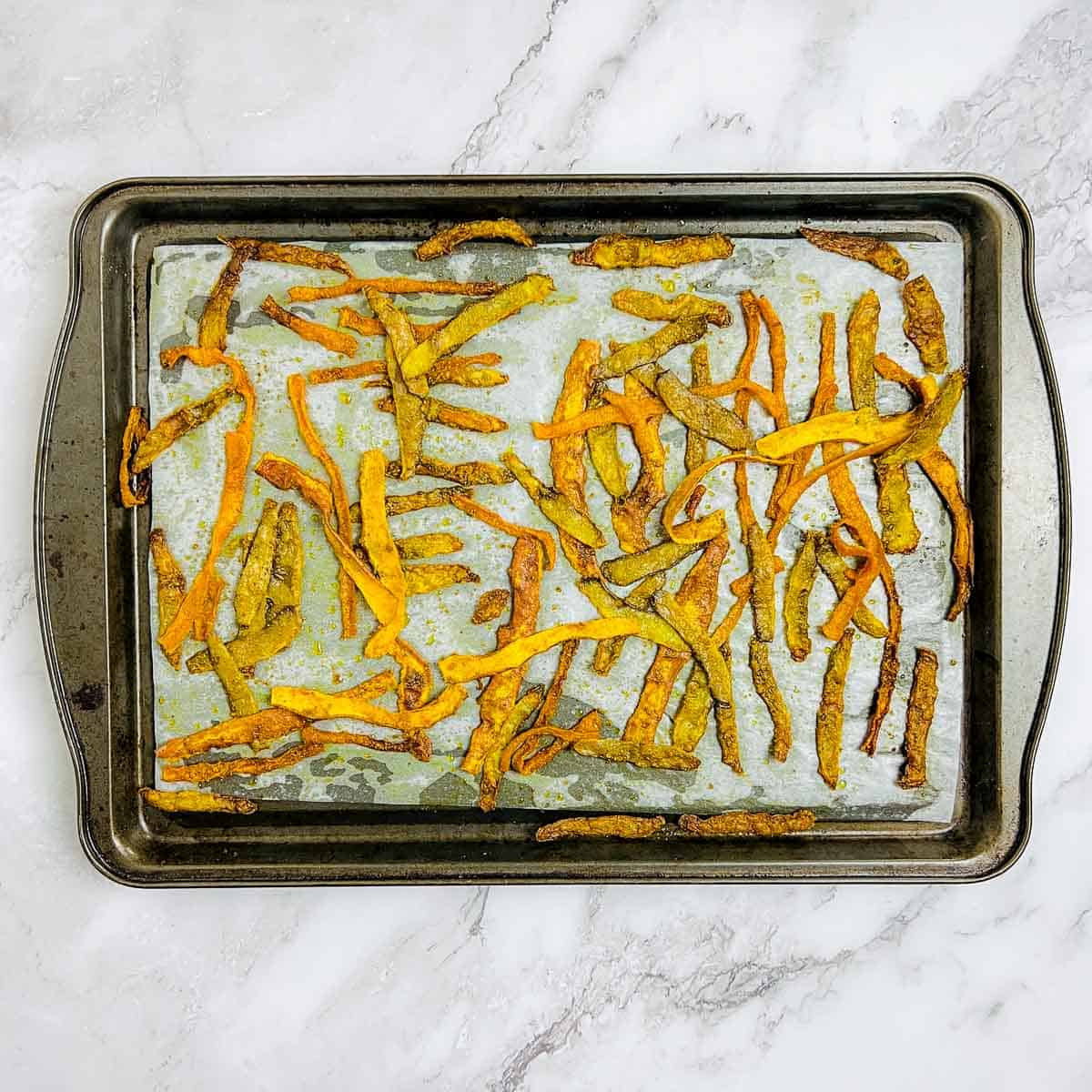 Baked peel chips in baking sheet.