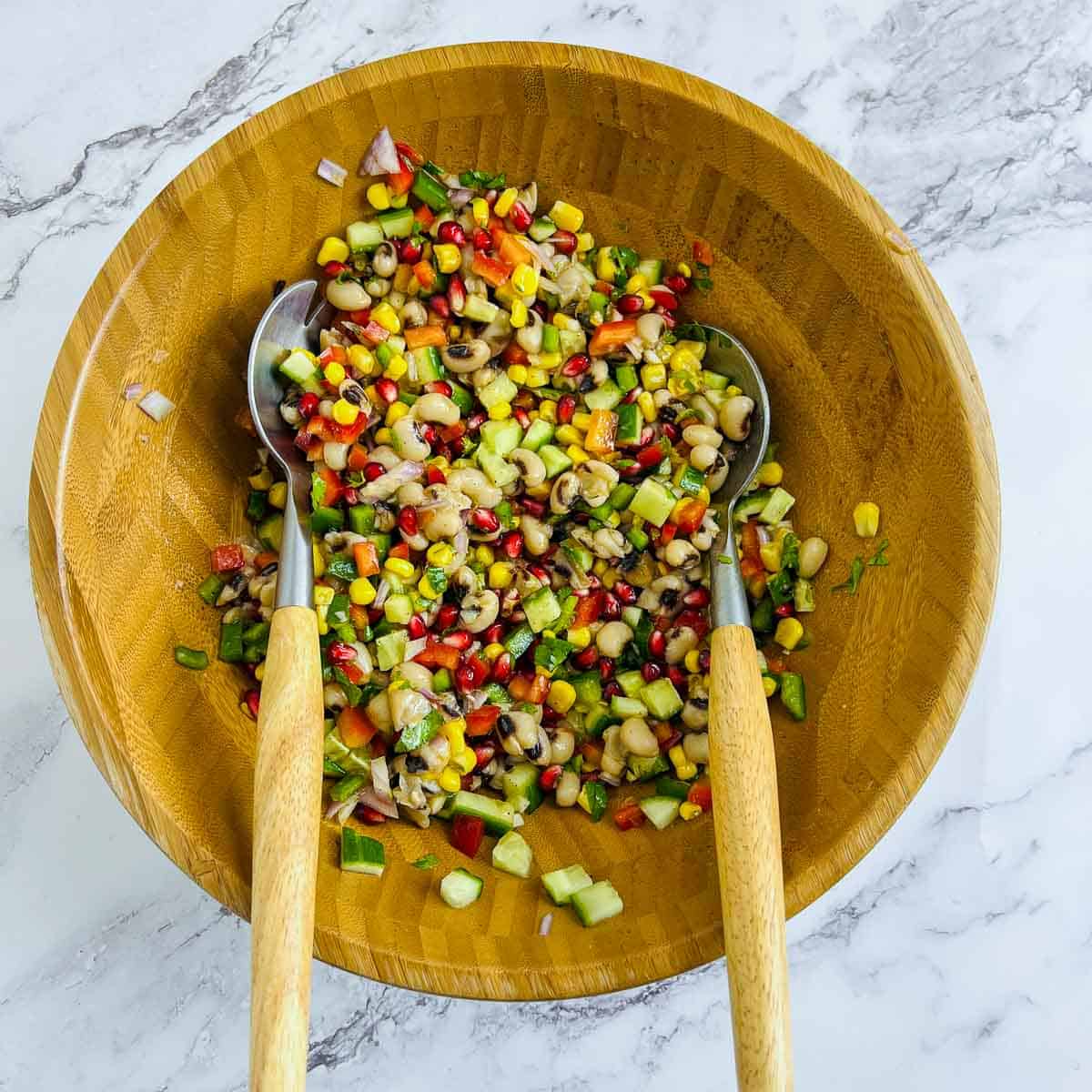 Dressing tossed with salad veggies and beans.