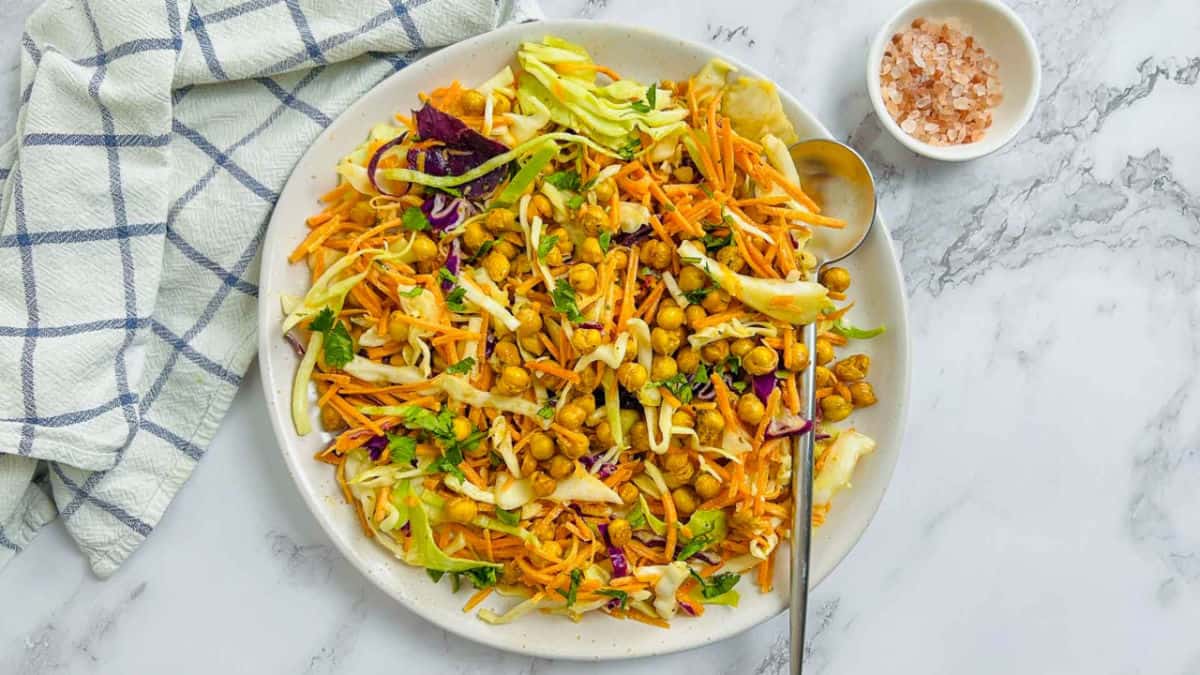 Chickpea crunch salad on a white plate with a spoon.