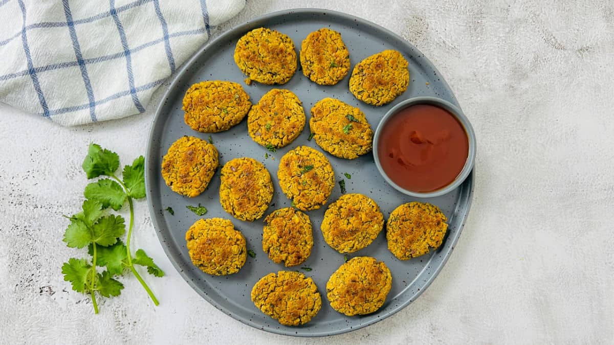 Chickpea nuggets on a grey plate served with ketchup.