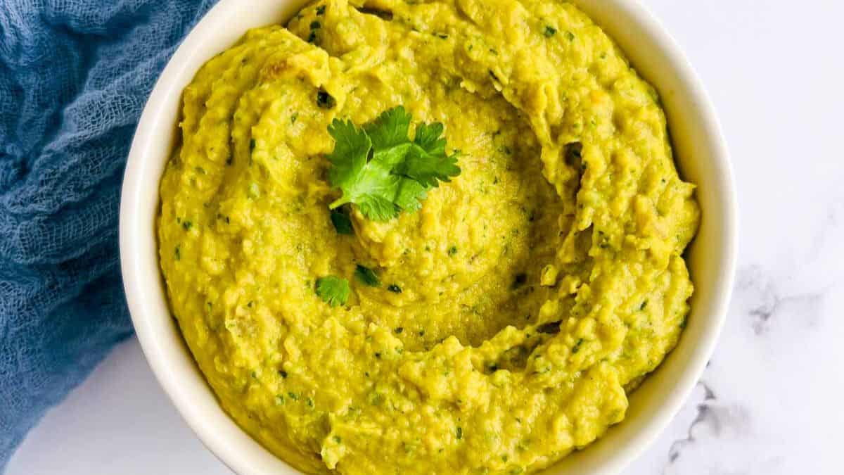Curried white bean dip in a white bowl.