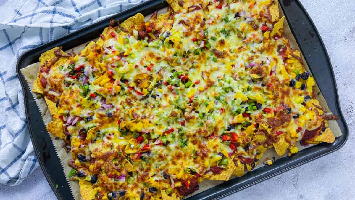 Loaded nachos on a sheet pan.