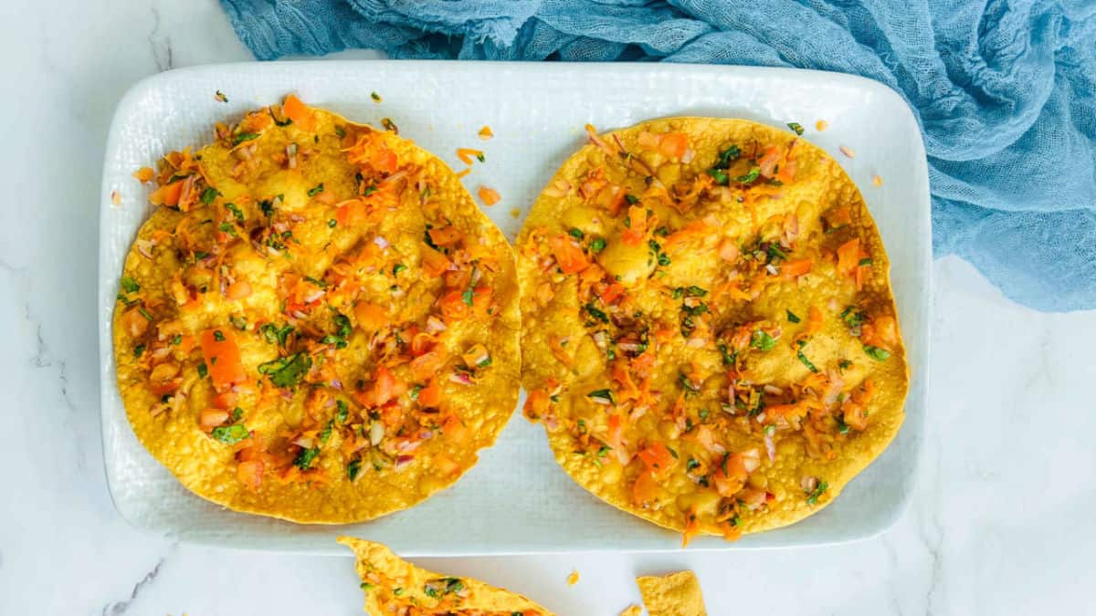 Two masala papad on a white plate.